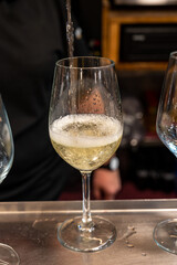 Pouring of txakoli or chacolí slightly sparkling very dry white wine produced in Spanish Basque Country in pinchos bar in old part of San Sebastian or Donostia, Spain