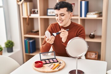 Young non binary man smiling confident applying makeup at home