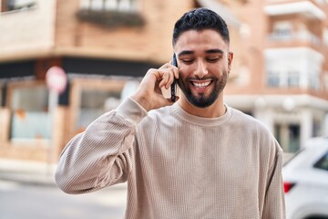 Young arab man smiling confident talking on the smartphone at street