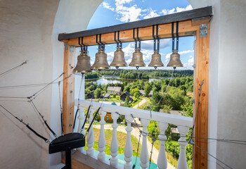 Orthodox bells on the church bell tower. Top view of the village and the lake