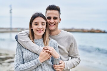 Man and woman couple hugging each other kissing at seaside