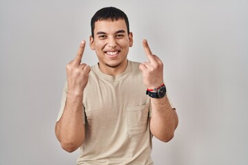 Fototapeta premium Young arab man wearing casual t shirt showing middle finger doing fuck you bad expression, provocation and rude attitude. screaming excited