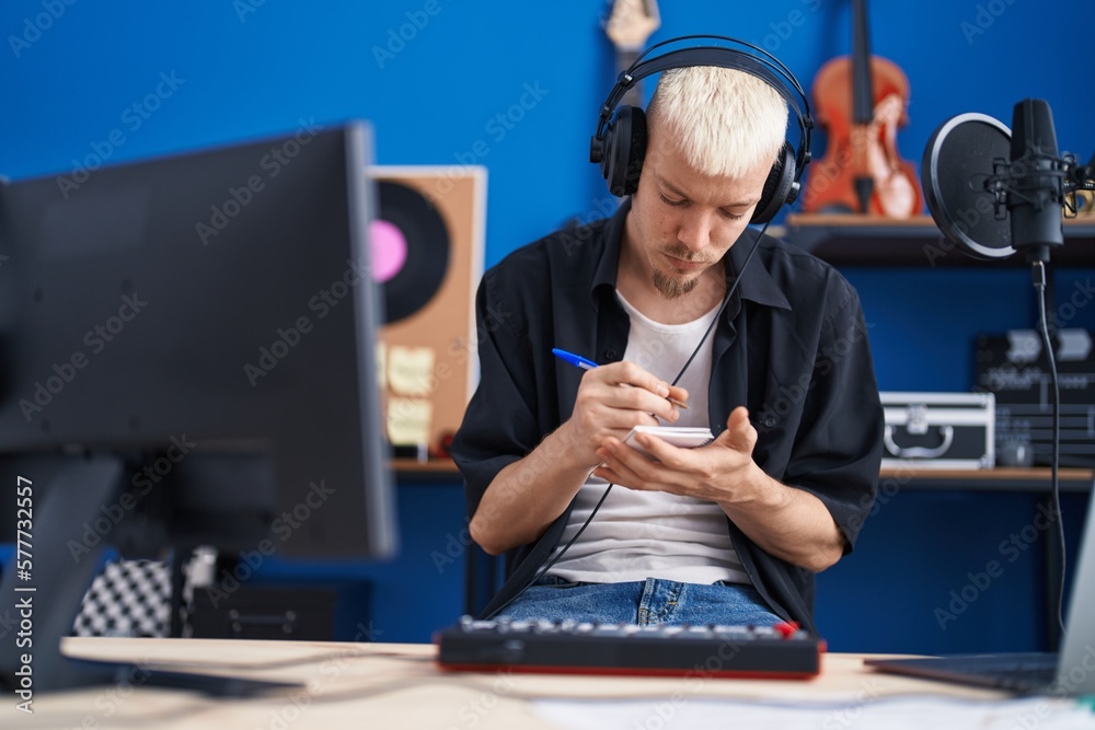 Sticker Young caucasian man musician composing song at music studio