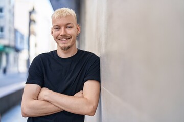 Young caucasian man smiling confident standing with arms crossed gesture at street