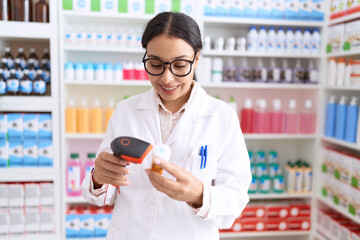 Young arab woman pharmacist scanning pills bottle at pharmacy