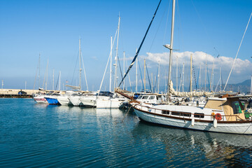 Fototapeta na wymiar Beautiful pier with luxury yachts on the blue sea shore under the hot summer sun
