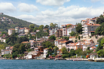 View from the sea of the green mountains of the Europian side of Bosphorus strait, with traditional houses and dense trees in a summer day, Istanbul, Turkey - Powered by Adobe