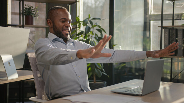 Funny African Businessman Mature Ethnic Middle Age 40s Man Manager CEO Agent Celebrate Good Business Profit Win Online Victory On Laptop Computer Dancing At Desk American Adult Worker In Sunny Office