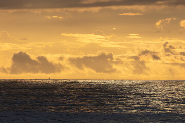 Bright and cloudy yellow sunset over the sea