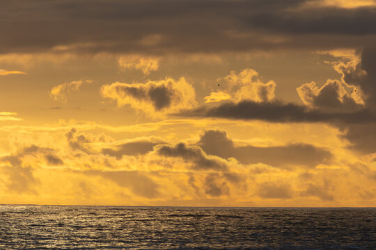 Bright yellow sunset over the dark sea