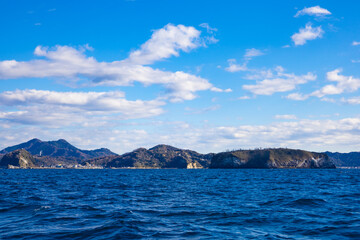 Fototapeta na wymiar 東京湾・金田湾でクルージングするヨットからの眺め・海上からの鋸山の町並みと海と波（千葉県鋸南市）