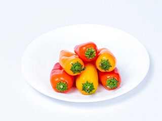 Colorful peppers stacked like wood on a white plate