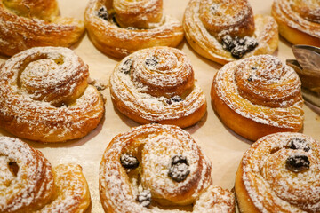 Croisants and cinnamon rolld in a display shelf.