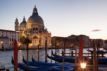 Naklejka premium Venezia.Basilica di Santa Maria della Salute al crepuscolo sul Canal Grande con gondole al palo 