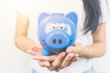 Close up two hand of woman holding piggy bank. Finance Savings and money wealth concept. Copy space.