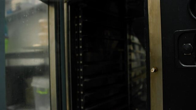 Kitchen in the bakery - the chef opens the combi steamer oven