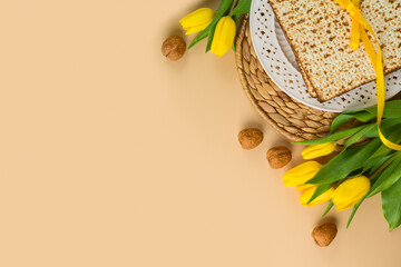 Jewish holiday Passover concept with matzah, seder plate and yellow tulip flowers on modern background. Top view, flat lay