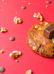 Cookie artesana de chocolate y nueces sobre fondo rosa