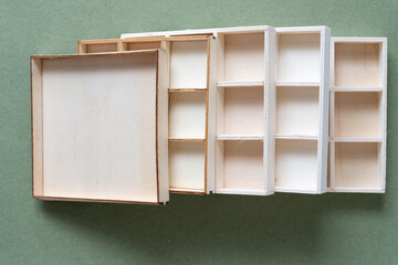 several shallow wooden boxes on rough green paper