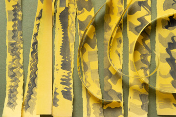 torn yellow paper stripes with somewhat wavy edges decorated with stained patterns
