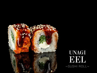 Side view of sushi roll pieces with mirror reflection on black background. Sushi roll with cream cheese, cucumber and eel, Unagi sauce on top. Ready menu advertising banner with text and copy space.