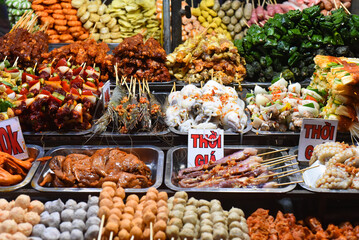 Many snacks and seafood in vietnamese night market with signs with vietnamese text of food's name in Da Lat