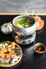 Korean hot pot with sea food and noodles on black background