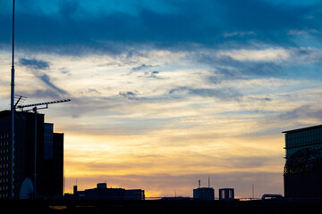 都会の空に広がるビルと幻想的な青とオレンジのグラデーションの夕焼け空と少しの雨雲（東京都千代田区）