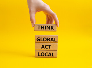 Think global act local symbol. Wooden blocks with words Think global act local. Beautiful yellow...