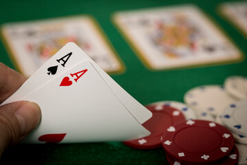 Closeup of hands with two aces, Texas Hold'em Poker gambling concept	
