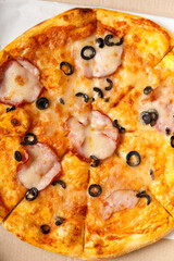 Pizza with meat and olives top view.