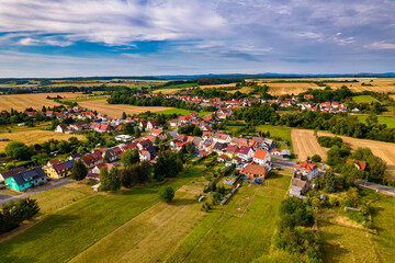 Aer ial view of a German village surrounded by meadows, farmland and forest in Germany.