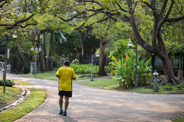 Fototapeta premium Senior old man running or jogging in park at sunrise