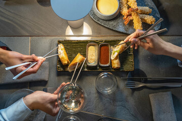 Asian Fusion Food with Spring Rolls and Tempura Shrimps on Table