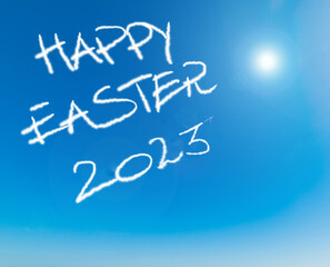 Happy Easter 2023 written in the blue sky under a shining sun