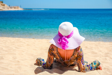 Beautiful pregnant girl in hat at sea background