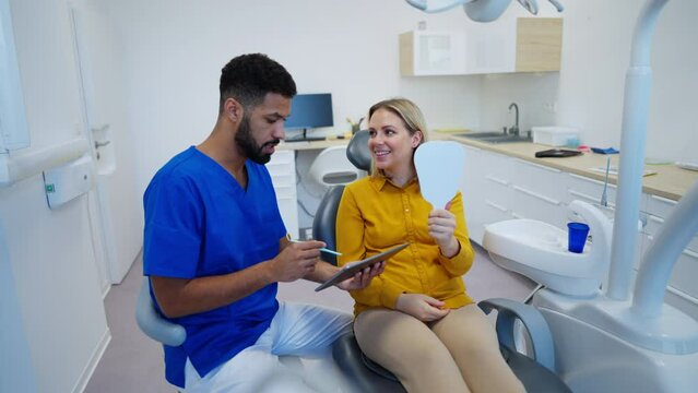 Dentist doing a consultation with digital tablet with his patient.