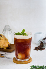 Iced black tea with lychee on wood coaster and white background