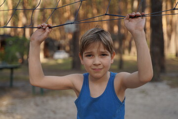 Fototapeta premium Teenage sports fashion. Photo of smiling teen boy in sportswear near volleyball net.