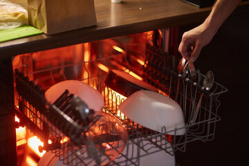 Clean plates after washing in the dishwasher. Close-up of the dishes placed in the dishwasher....