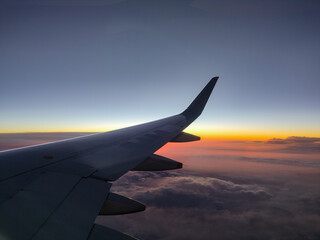 Fototapeta na wymiar Photography of the plane's wing through the window, beautiful evening in the air