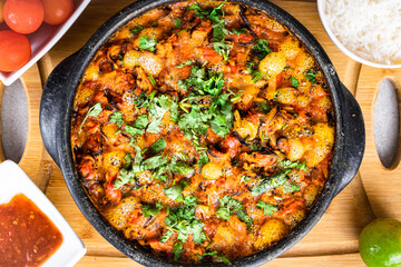 Charru Mussel, known in Brazil as Sururu Moqueca, on wooden board. Beside pepper, lemon, small tomatoes and rice.