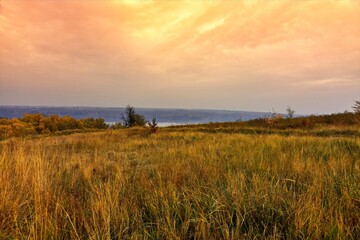 Red sunset over the river and a beautiful field.