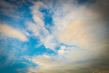 Naklejka na ściany i meble Fluffy white clouds and blue skies during sunset