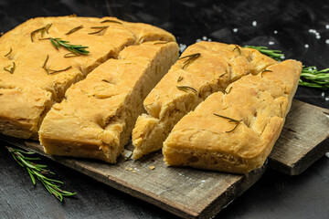 foccacia bread. olive oil and herbs on a dark background. banner, menu, recipe place for text, top view