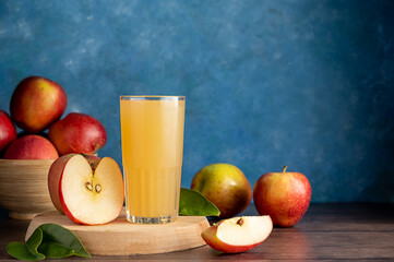 Apple cider cocktail, juice drink with fresh red apples, blue vibrant background, copy space