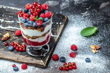 yogurt granola parfait with blueberry and raspberry on a light background. Long banner format