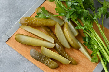 Pickled cucumbers sliced on a chopping board