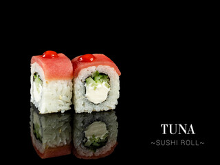 Close up to inside out sushi roll pieces with mirror reflection on black background. Sushi roll with cucumber, cream cheese and tuna fish on top Ready menu advertising banner with text and copy space.