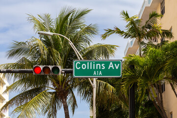 Low angle view of Collins Avenue sign on street light with buildings in soft focus background,...